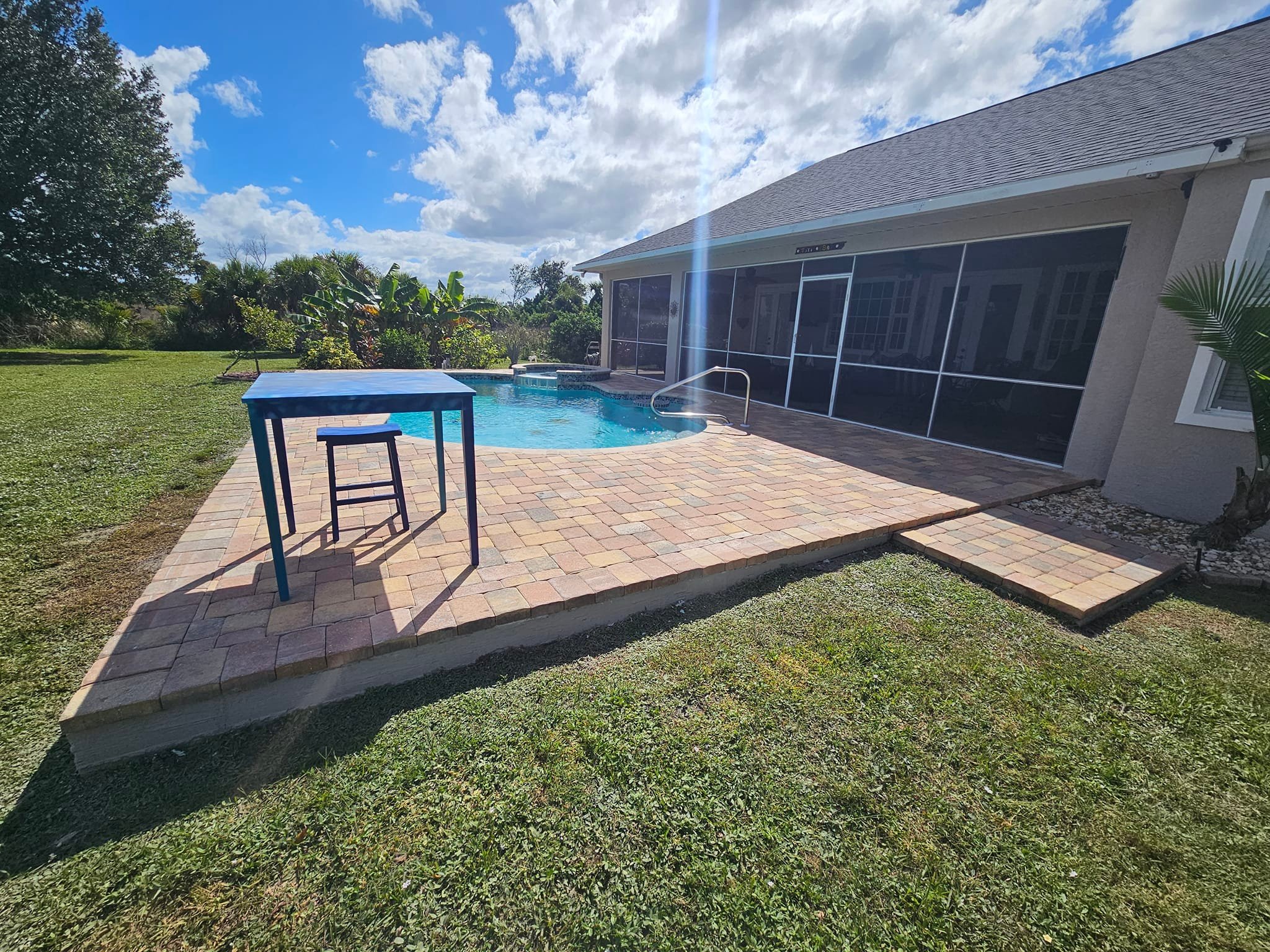 Beautiful pool patio with custom pavers surrounding the pool, creating a durable and stylish outdoor space.