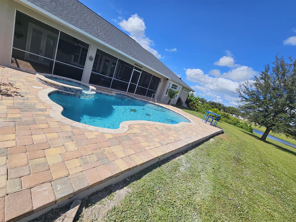 View of a pool patio with custom pavers, highlighting the elegant design and seamless integration with the pool’s surroundings.