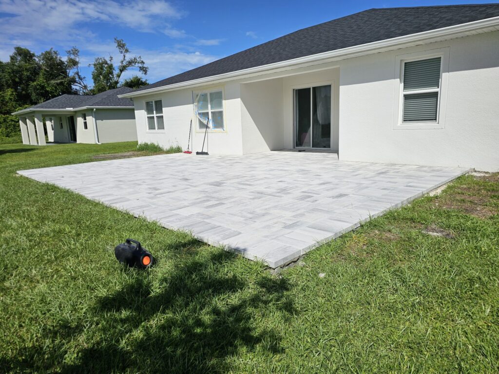 Newly installed white stone patio in a backyard with a clean, modern design and fresh landscaping