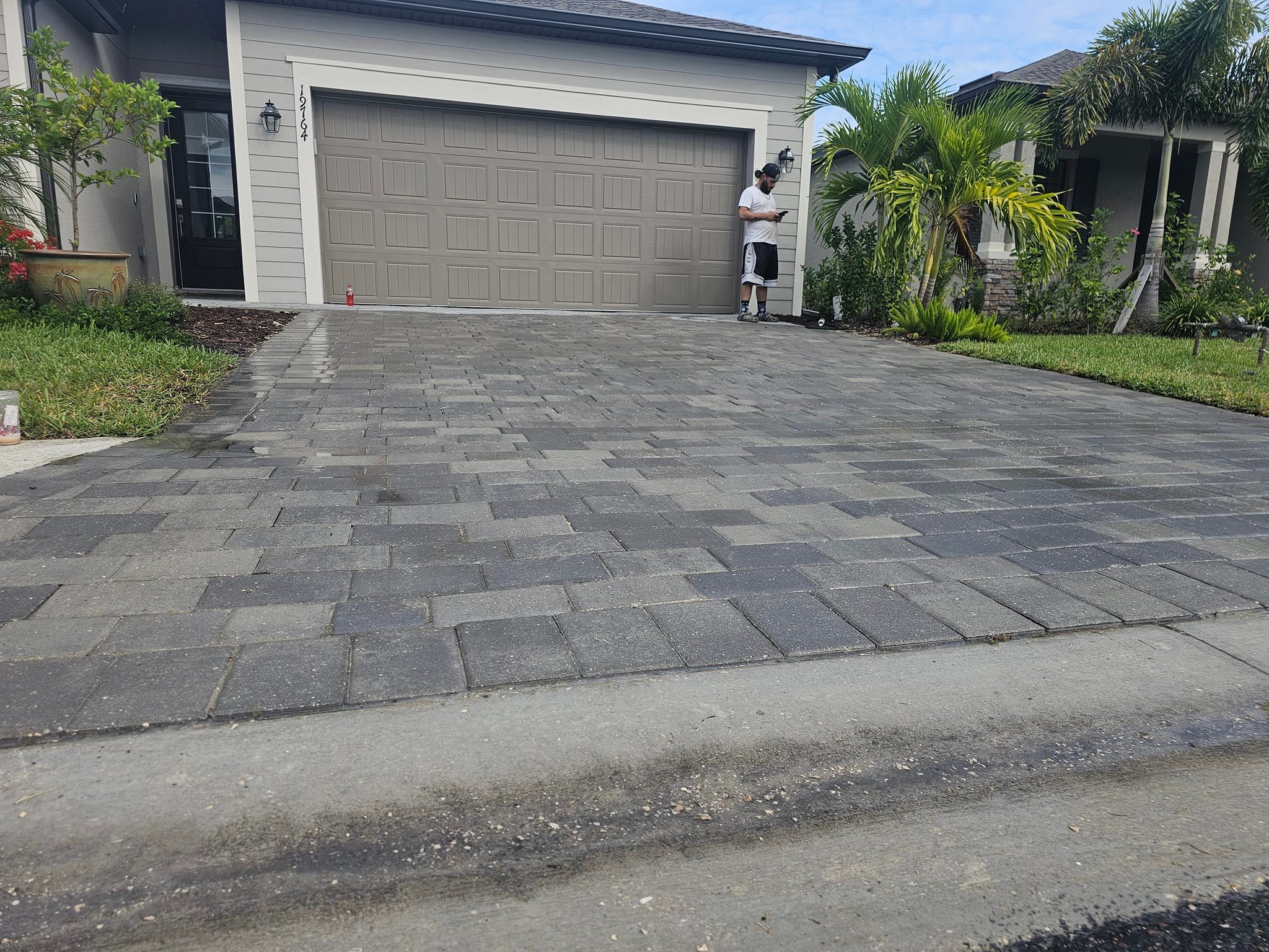 Elegant driveway with gray pavers arranged in a sleek pattern, enhancing the curb appeal of a modern home.